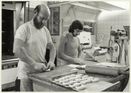Bakker H. van Asselt en medewerker aan het werk in de bakkerij in de Theemsstraat 60. NL-HlmNHA 54009607