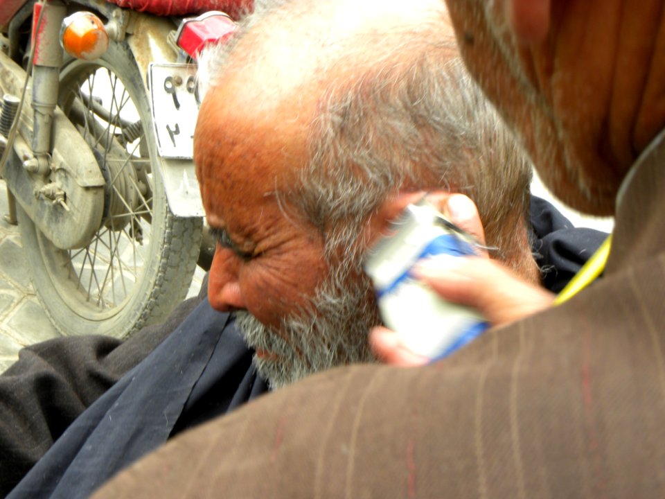 Barber on the sidewalk of a street in Nishapur 1