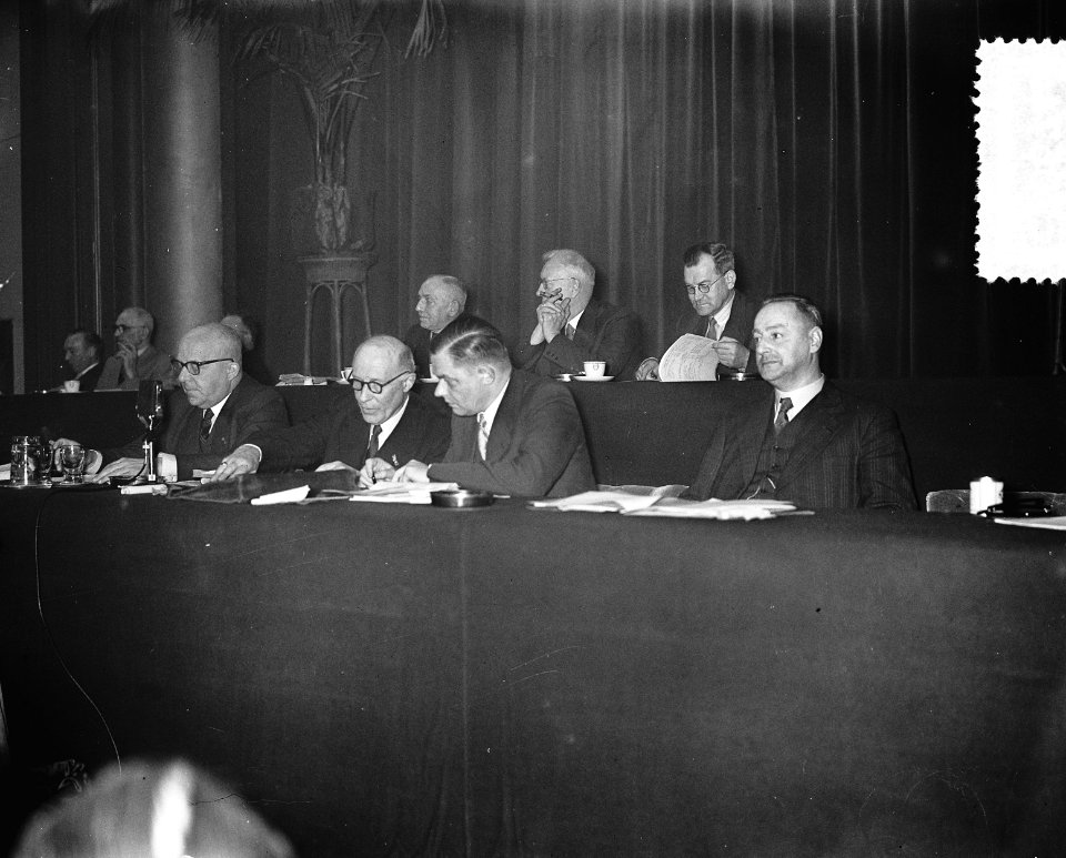 Bestuurstafel met in het midden Tilanus (rechts naast hem Beernink), Bestanddeelnr 907-0674