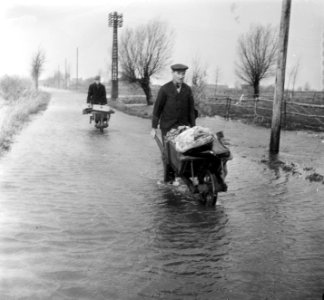 Bewoners evacueren met persoonlijke bezittingenin kruiwagens, Bestanddeelnr 905-5147