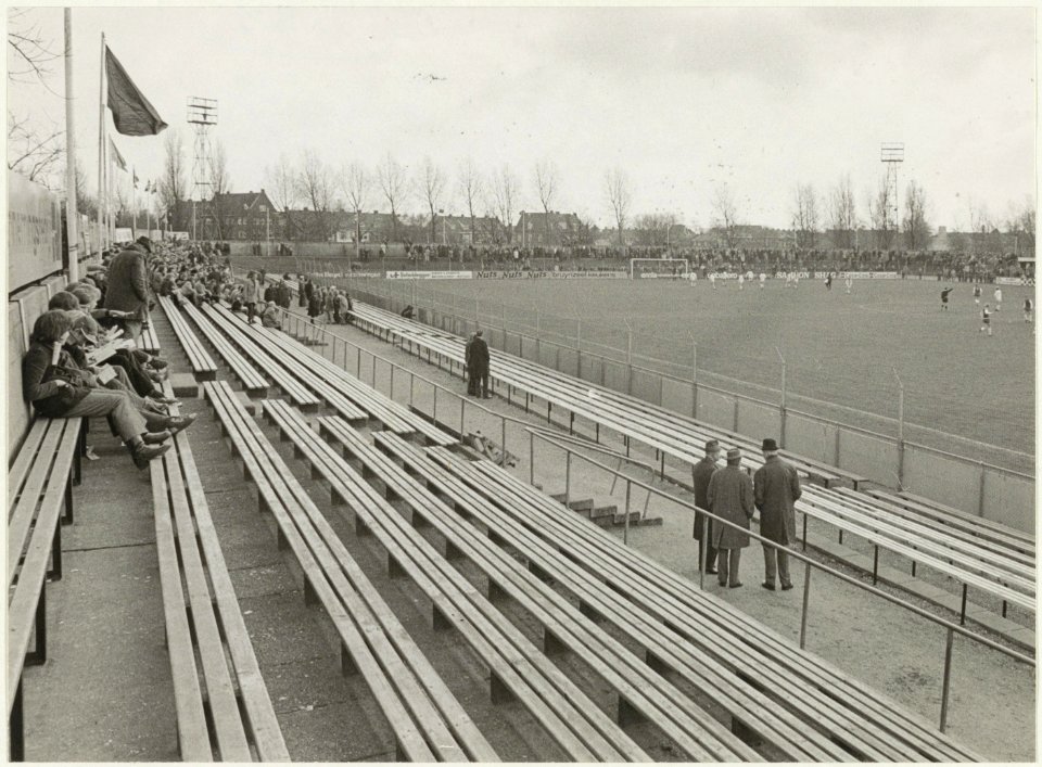 Bezoekers kijken vanaf de tribune naar de wedstrijd Haarlem - M.V.V. (3-2) tijdens het voetbalseizoen 19721973. NL-HlmNHA 54024745