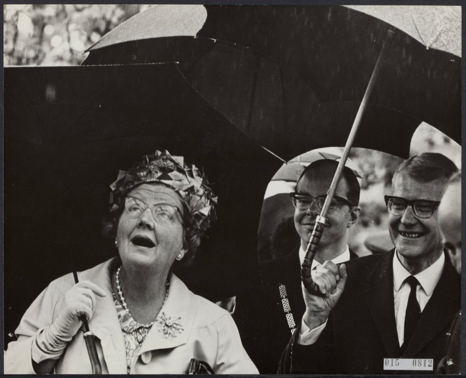 Bezoek van koningin Juliana aan Boskoop, in de regen. Achter haar burgemeester V, Bestanddeelnr 015-0812