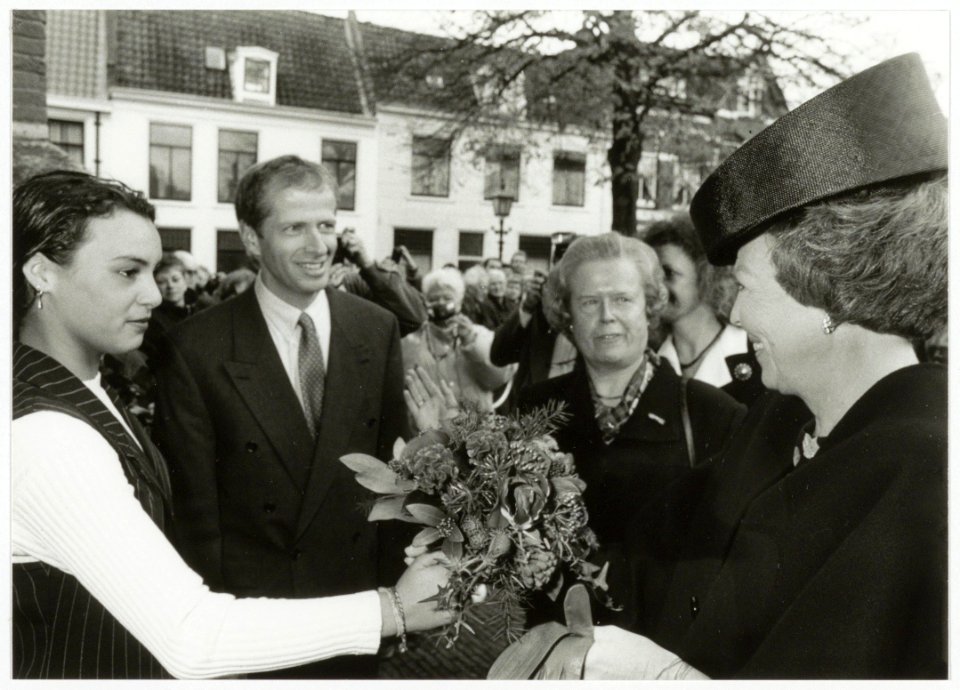 Bezoek van Koningin Beatrix aan het jubilerende Coen Cuserhuis. De bloemen worden bij de Nieuwe Kerk aangeboden door Gaby van Rhoon (opgegroeid in een van de opvanghuizen van de Stichting Je, NL-HlmNHA 54035328