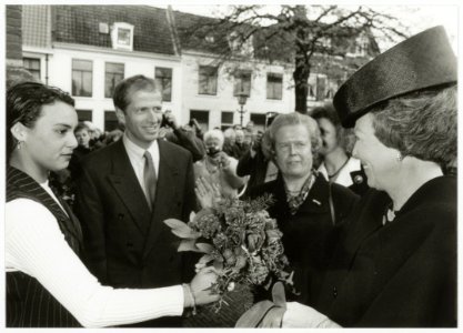 Bezoek van Koningin Beatrix aan het jubilerende Coen Cuserhuis. De bloemen worden bij de Nieuwe Kerk aangeboden door Gaby van Rhoon (opgegroeid in een van de opvanghuizen van de Stichting Je, NL-HlmNHA 54035328