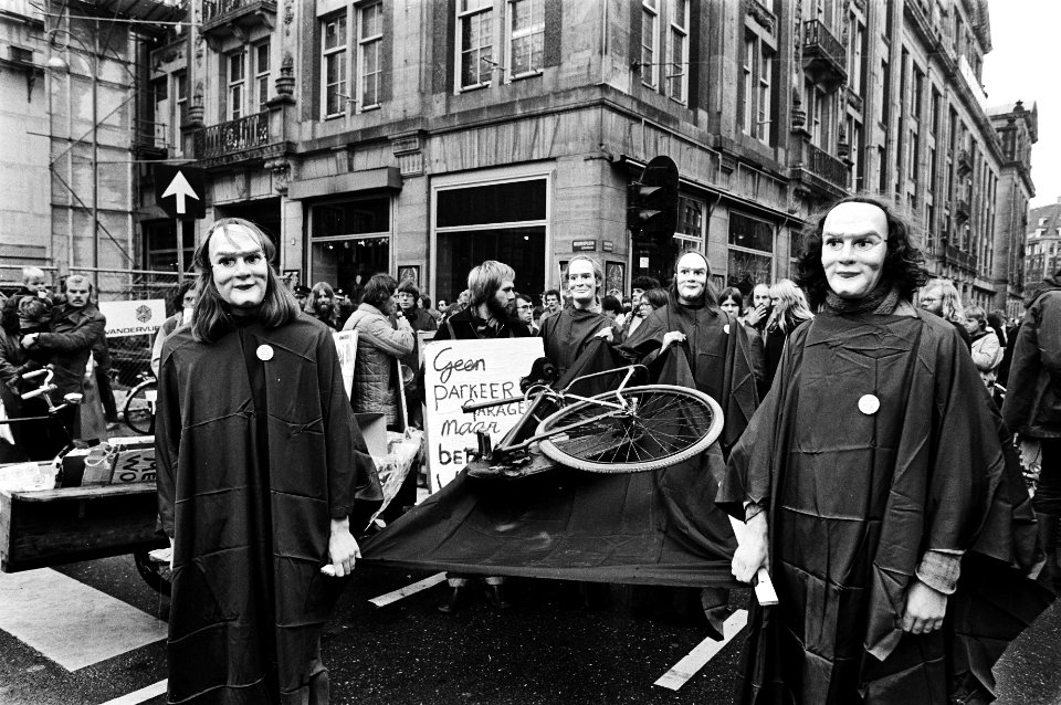 Betogers in rouwkleren begraven een fiets en voeren spandoeken mee Geen par…, Bestanddeelnr 930-5332
