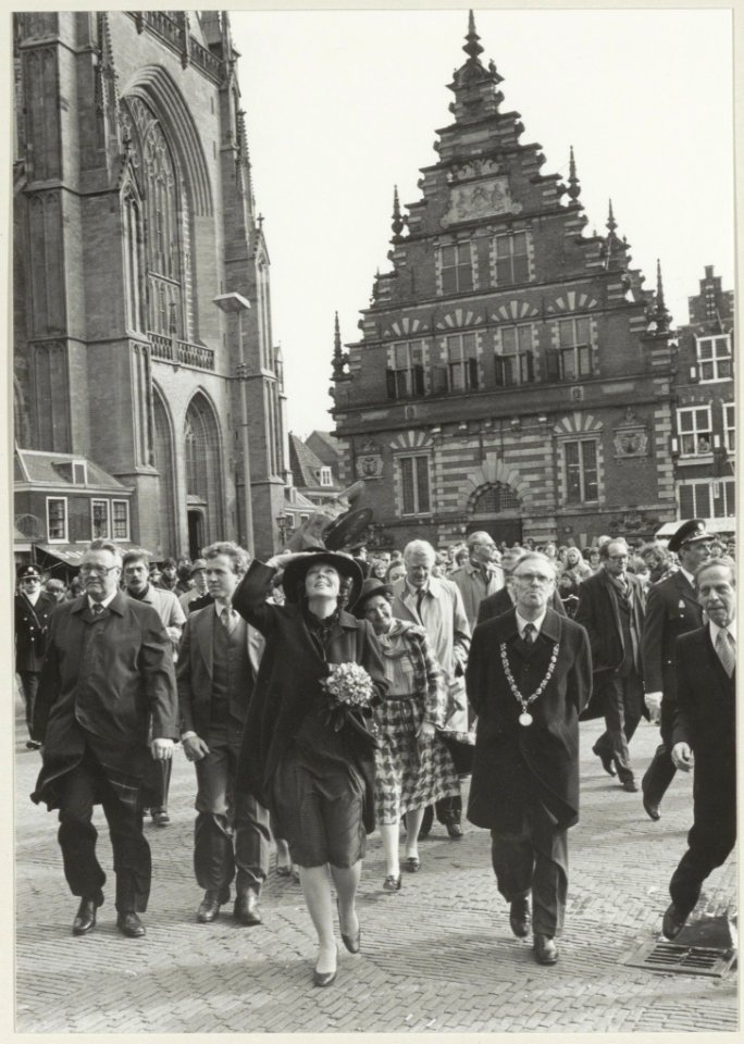 Bezoek van Koningin Beatrix aan Haarlem. Links met regenjas de Commissaris van de Koning in Noord-Holland R. de Wit, in het midden Koningin Beatrix en rechts burgemeester Reehorst. NL-HlmNHA 54013938