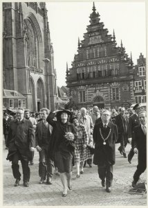 Bezoek van Koningin Beatrix aan Haarlem. Links met regenjas de Commissaris van de Koning in Noord-Holland R. de Wit, in het midden Koningin Beatrix en rechts burgemeester Reehorst. NL-HlmNHA 54013938