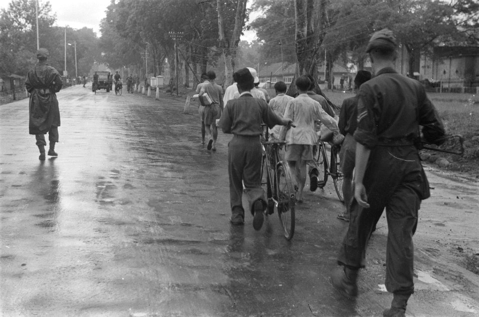 Bewapende Nederlandse militair en begeleiden een groep Indonesische mannen waarv, Bestanddeelnr 97-1-2