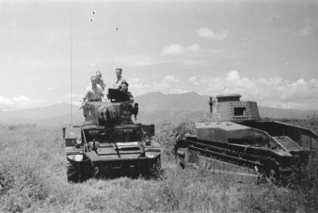 Bezoek aan een Eskadron Vechtwagens KNIL. Een Stuart tank passeert het wrak van , Bestanddeelnr 194A-3-4