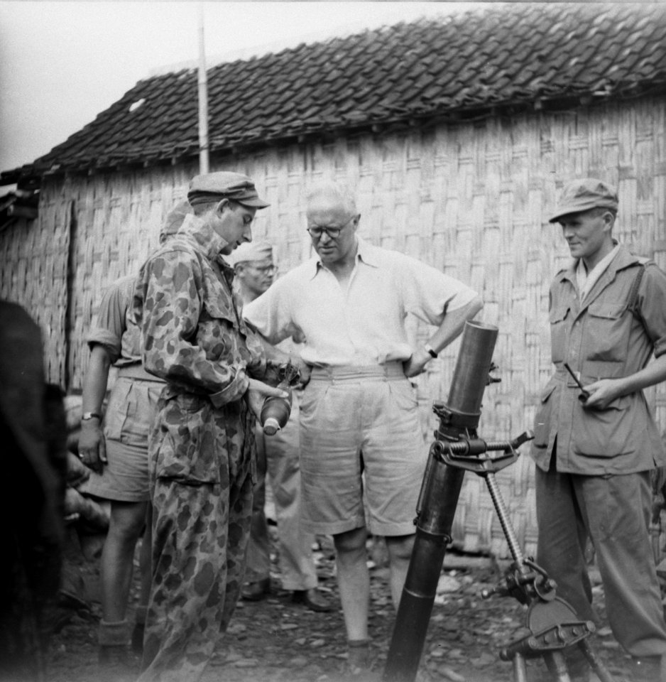 Bezoek aan het front. Een soldaat toont Romme een granaat van een mortier. Rech…, Bestanddeelnr 10808
