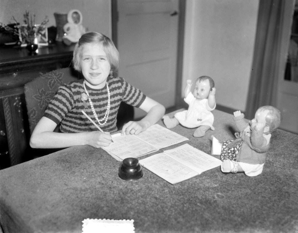 Bezoek bij Zwolse vierling Kiffers, Elly met poppen bij huiswerk, Bestanddeelnr 906-1820