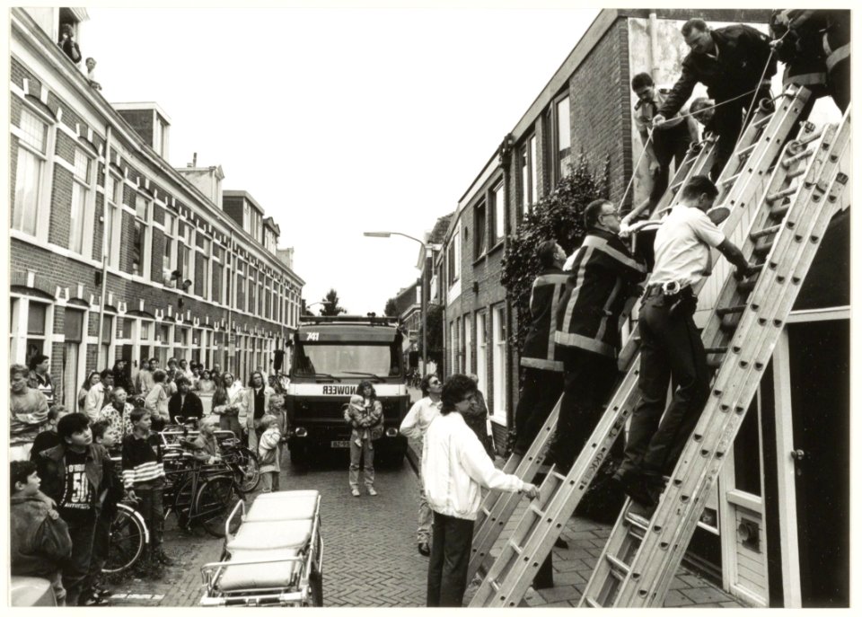 Bedrijfsongeval in de Esschildestraat. Vervoer van een gewonde schilder. NL-HlmNHA 54032120