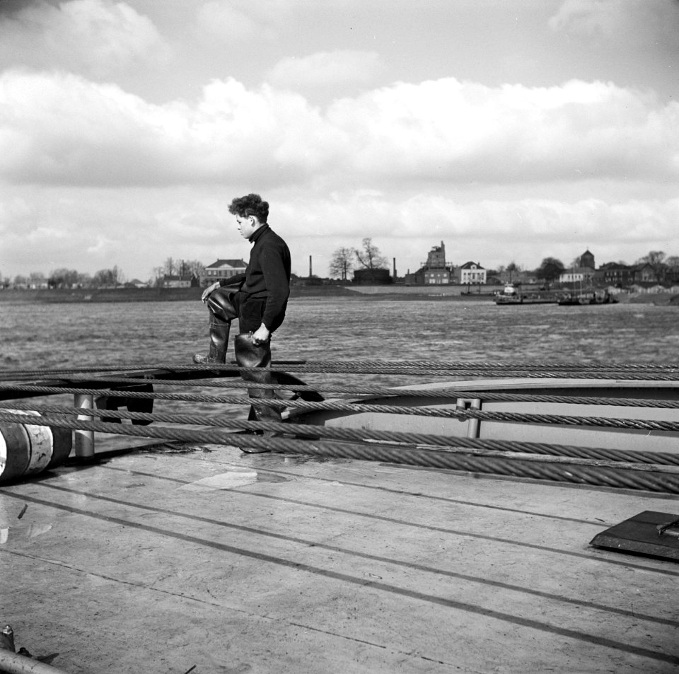 Bemanningslid Otto op de achtersteven van de sleepboot met op de achtergrond de…, Bestanddeelnr 254-0945