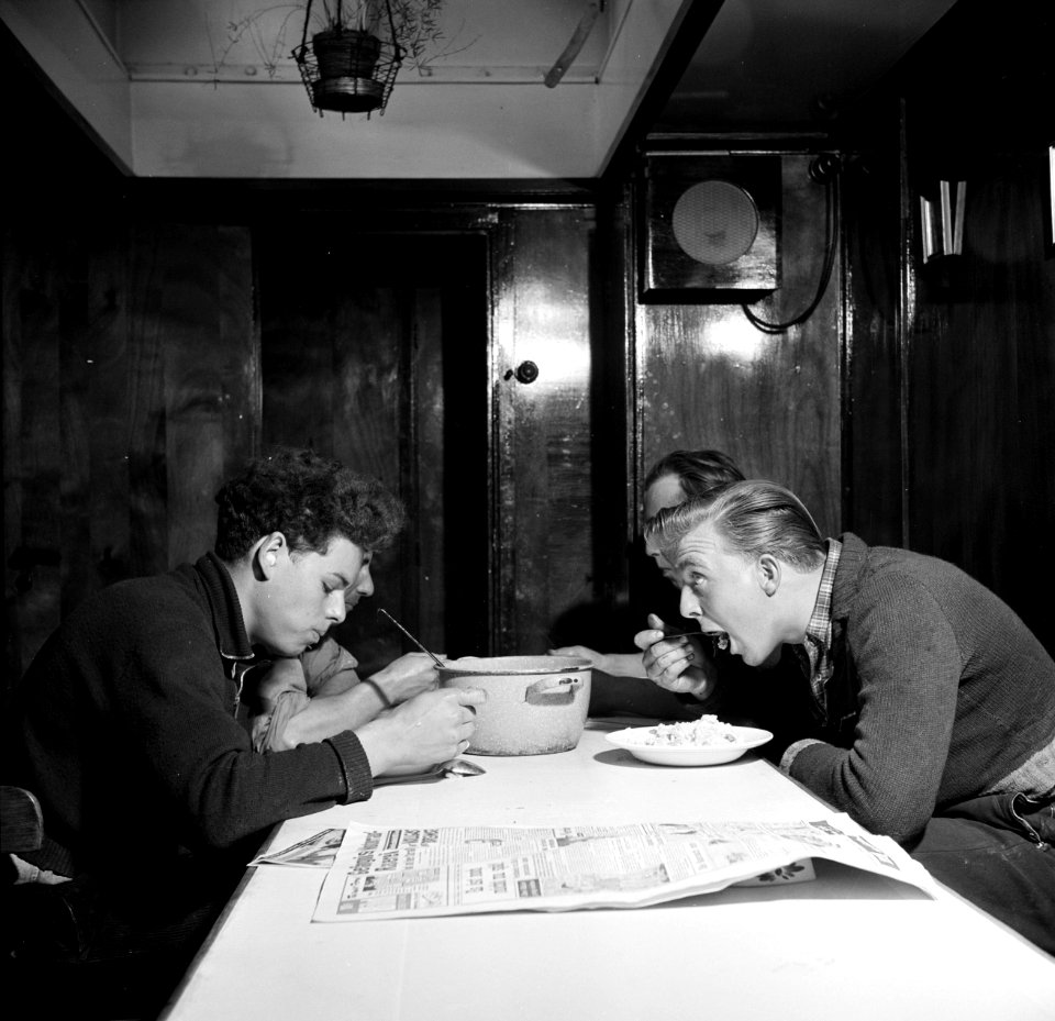 Bemanningsleden met links Otto en rechts Arthur aan de maaltijd aan boord van d…, Bestanddeelnr 254-1409