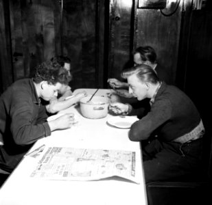Bemanningsleden met links Otto en rechts Arthur aan de maaltijd aan boord van d…, Bestanddeelnr 254-1412