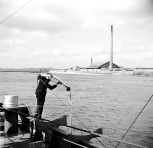 Bemanningslid Otto poetst de davit van een reddingsboot van de sleper Damco 9, …, Bestanddeelnr 254-1389