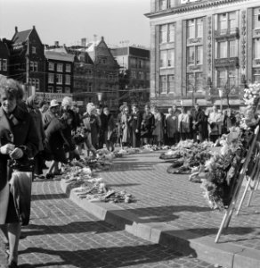 Belangstellenden leggen bloemen bij het Monument op de Dam tijdens dodenherdenki, Bestanddeelnr 926-3890