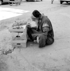Bejaarde man met handelswaar in banenendozen langs de kant van de weg, Bestanddeelnr 255-3530