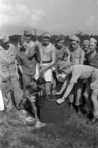 Behendigheidsrit voertuigen. Mannen rond een vat met water waarin een soldaat me, Bestanddeelnr 393-6-5