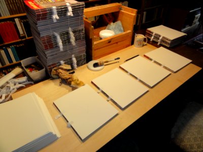 Boekbindclub Dukenburg Tijdschriftbinden 014 de 2 cm uitstekende stukjes naaiband worden op de schutvellen geplakt