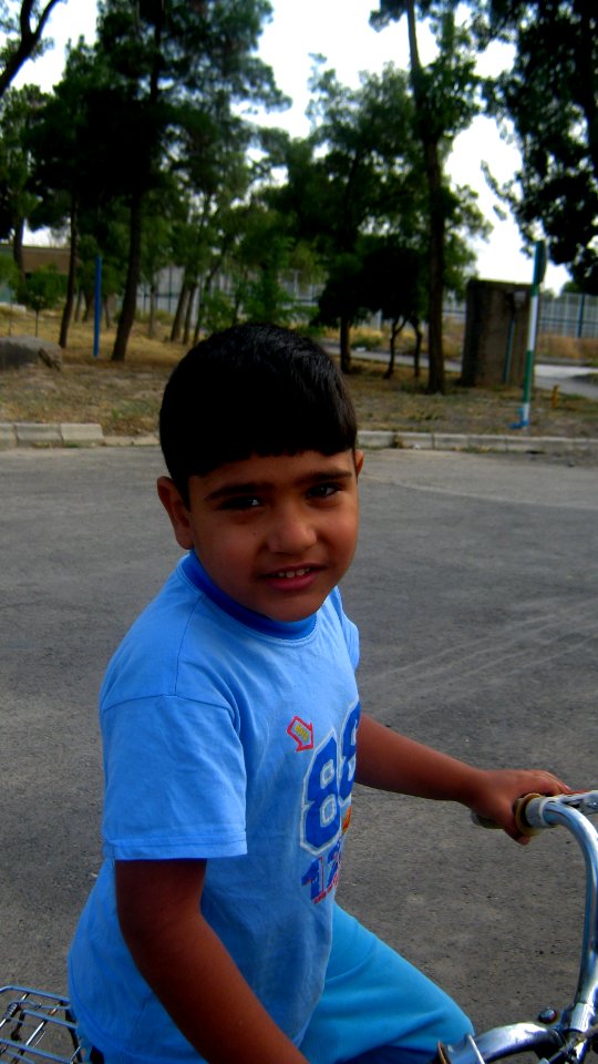 Blue clothed little cyclist boy - cycling near Nishapur railway station 02