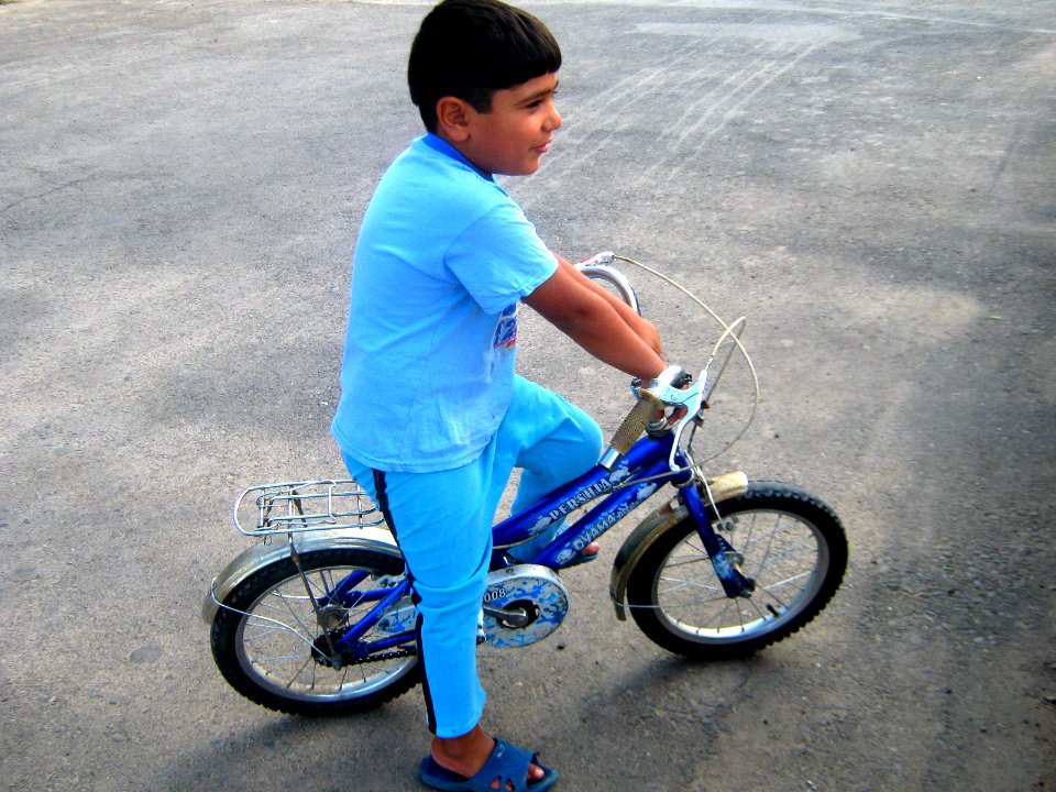Blue clothed little cyclist boy - cycling near Nishapur railway station 04