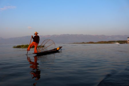 Boatman rowing with leg at Inle Lake photo