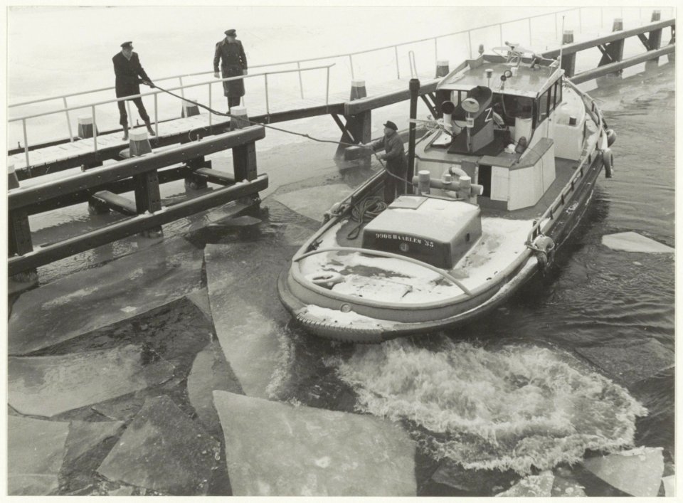 Bootje van de Havendienst in het ijs in het Spaarne. NL-HlmNHA 54016849