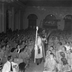Binnnenkomst van Sint-Nicolaas en Zwarte Pieten in een zaal vol met militairen, Bestanddeelnr 12603