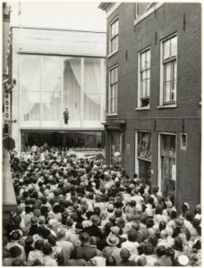 Bij modehuis Lampe in de grote Houtstraat werd voor het raam een mode show gegeven, ziende vanuit de Nieuwstraat naar het oosten. NL-HlmNHA 54005578