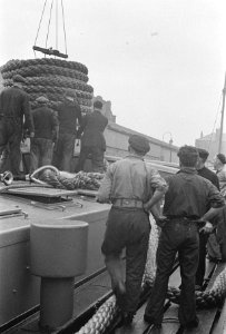 Bijschrift The towing rope being brought aboard het sleeptouw wordt aan boord, Bestanddeelnr 935-2983