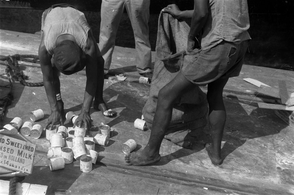 Blikjes zoete gecondenseerde melk uit Holland worden van de kade opgeraapt en in, Bestanddeelnr 1578