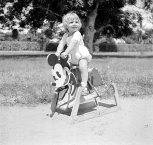 Blond kindje op een Mickey Mouse hobbelpaard in Suriname, Bestanddeelnr 252-6865