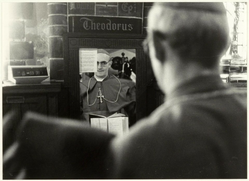 Bisschop Bomers in kijkt in de spiegel met het opschrift Theodorus ( van overleden bisschop Zwartkruis) in de sacristie van de Kathedraal St. Bavo, na zijn installatie. NL-HlmNHA 54025676