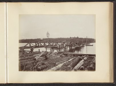 Brug in aanbouw. In de voorgrond boomstammen, Bestanddeelnr 852 11