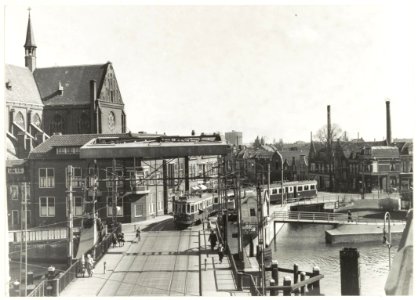 Budapester stel van de NZH (blauwe tram) is net de Langebrug gepasseerd en rijdt via Antoniestraat richting Herensingel, op weg naar Amsterdam. Links is een deel van de Spaarnekerk te zien