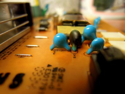 Burnt high-voltage capacitor of type LYSL6KV5D on an adaptor-inverter board of type AIVP-0065C by Lien Chang power-supplying an M2762D TV by LG