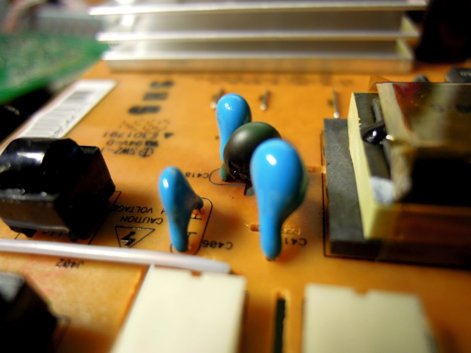Burnt high-voltage capacitor of type LYSL6KV5D on an adaptor-inverter board of type AIVP-0065C by Lien Chang power-supplying an LG M2762D