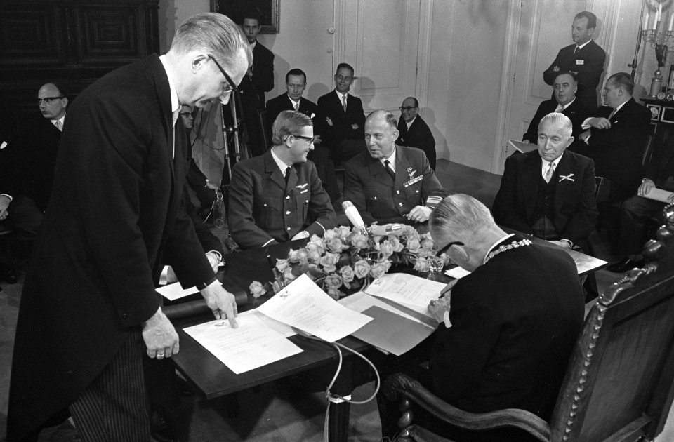 Burgemeester De Ranitz tekent de geboorteakte. Tegenover hem vlnr. Pieter van Vo, Bestanddeelnr 921-2708