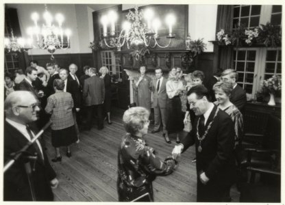 Burgemeester IJsselmuiden schudt handen tijdens de Nieuwjaarsreceptie in het raadhuis te Halfweg. NL-HlmNHA 54023546