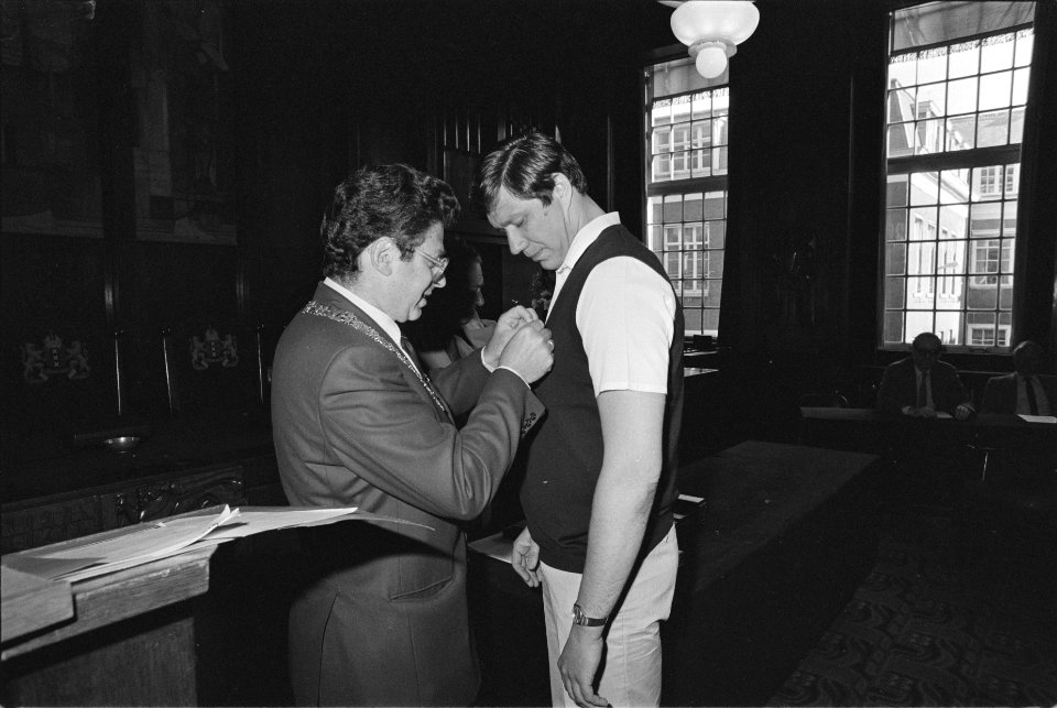 Burgemeester Van Thijn spelt het lintje op bij A.G.J. Buunk, Bestanddeelnr 932-9481