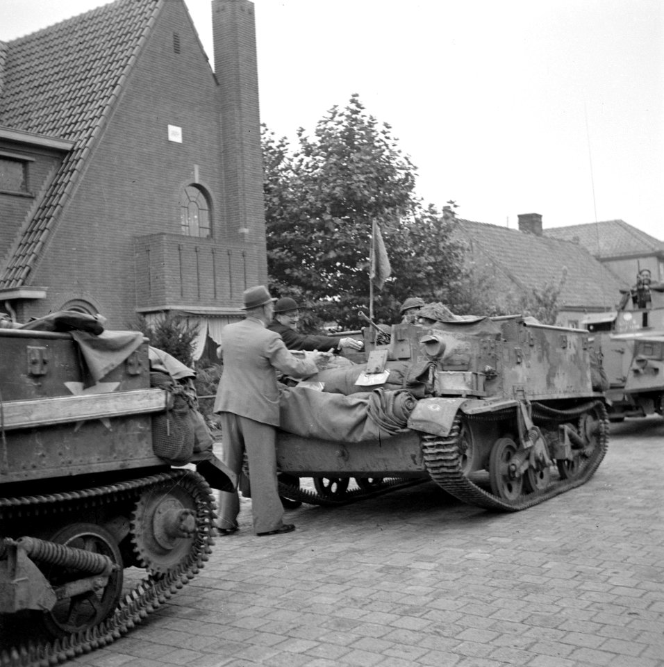 Burgers en pastoor delen bij de bevrijding fruit uit aan militairen in pantservo, Bestanddeelnr 255-9195