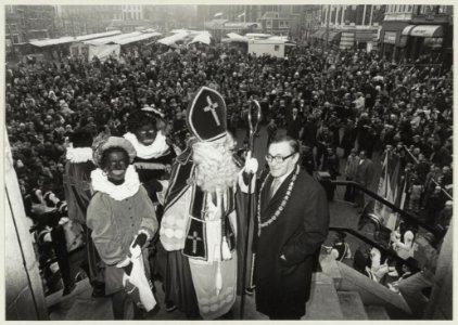 Burgemeester De Gou en Sinterklaas op het bordes, met zicht op de Grote Markt vol mensen. NL-HlmNHA 54009628