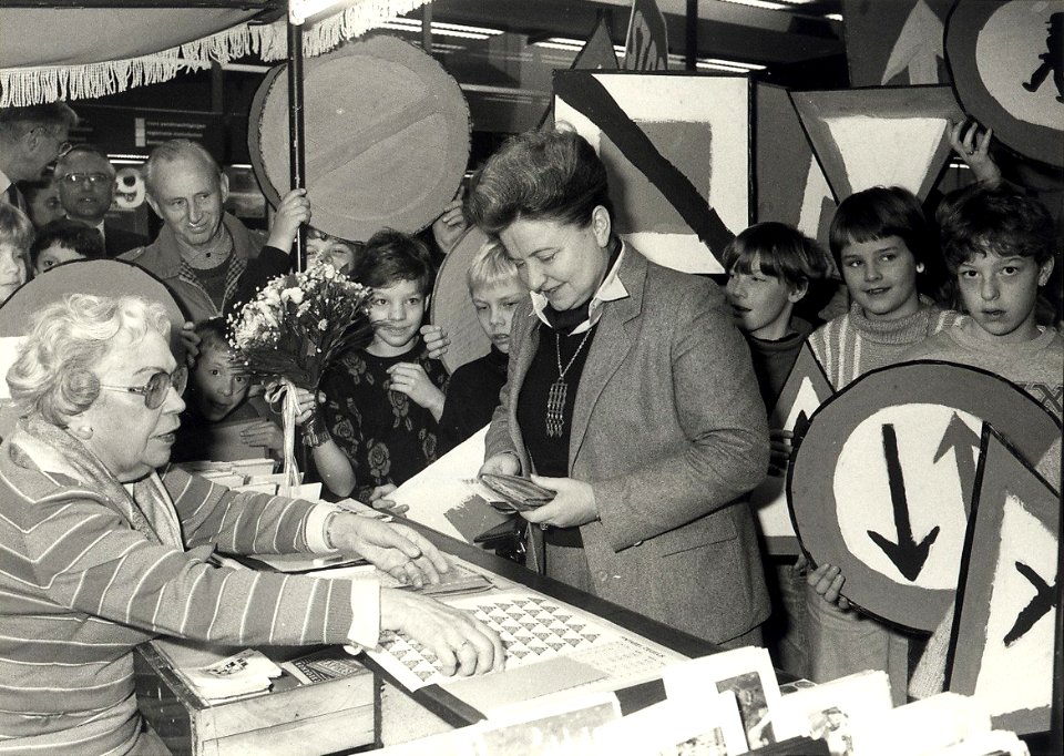 Burgemeester Schmitz koopt de eerste kinderzegles in het postkantoor. Aangekocht in 1987 van United Photos de Boer bv. - Negatiefnummer 25709 k 7. - Gepubliceerd in het Haarlems Dagblad van , NL-HlmNHA 54015450