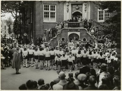 Burgemeester Van Fenema opent vanaf het bordes van het raadhuis de sportweek. NL-HlmNHA 54004039
