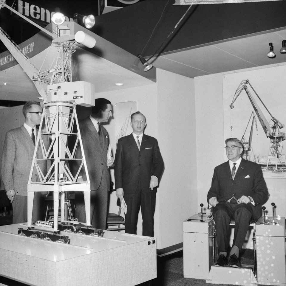 Burgemeester Thomassen (r.) terwijl hij het schaalmodel van een havenkraan uitpr, Bestanddeelnr 918-4373