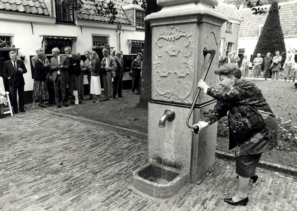 Burgemeester E.M.A. Schmitz heropent in de Barrevoetestraat het Hofje van Loo of Gasthuishofje. Aangekocht in 1988 van United Photos de Boer bv. - Negatiefnummer 28110 k 13 a. - Gepubliceerd in het Ha