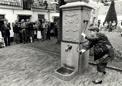 Burgemeester E.M.A. Schmitz heropent in de Barrevoetestraat het Hofje van Loo of Gasthuishofje. Aangekocht in 1988 van United Photos de Boer bv. - Negatiefnummer 28110 k 13 a. - Gepubliceerd in het Ha