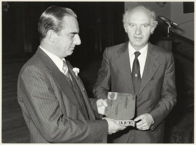 Burgemeester F.G.L.L. Schols van Den Haag overhandigt aan de heer Vermaire (links) de 14 wapenborden van de fam. De Raet, in de Gravenzaal van het stadhuis. NL-HlmNHA 54012624