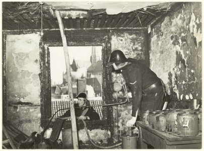 Brandweerlieden tijdens het blussen van brand in de lampekappenfabriek van Fa. Koelemans. NL-HlmNHA 54005503